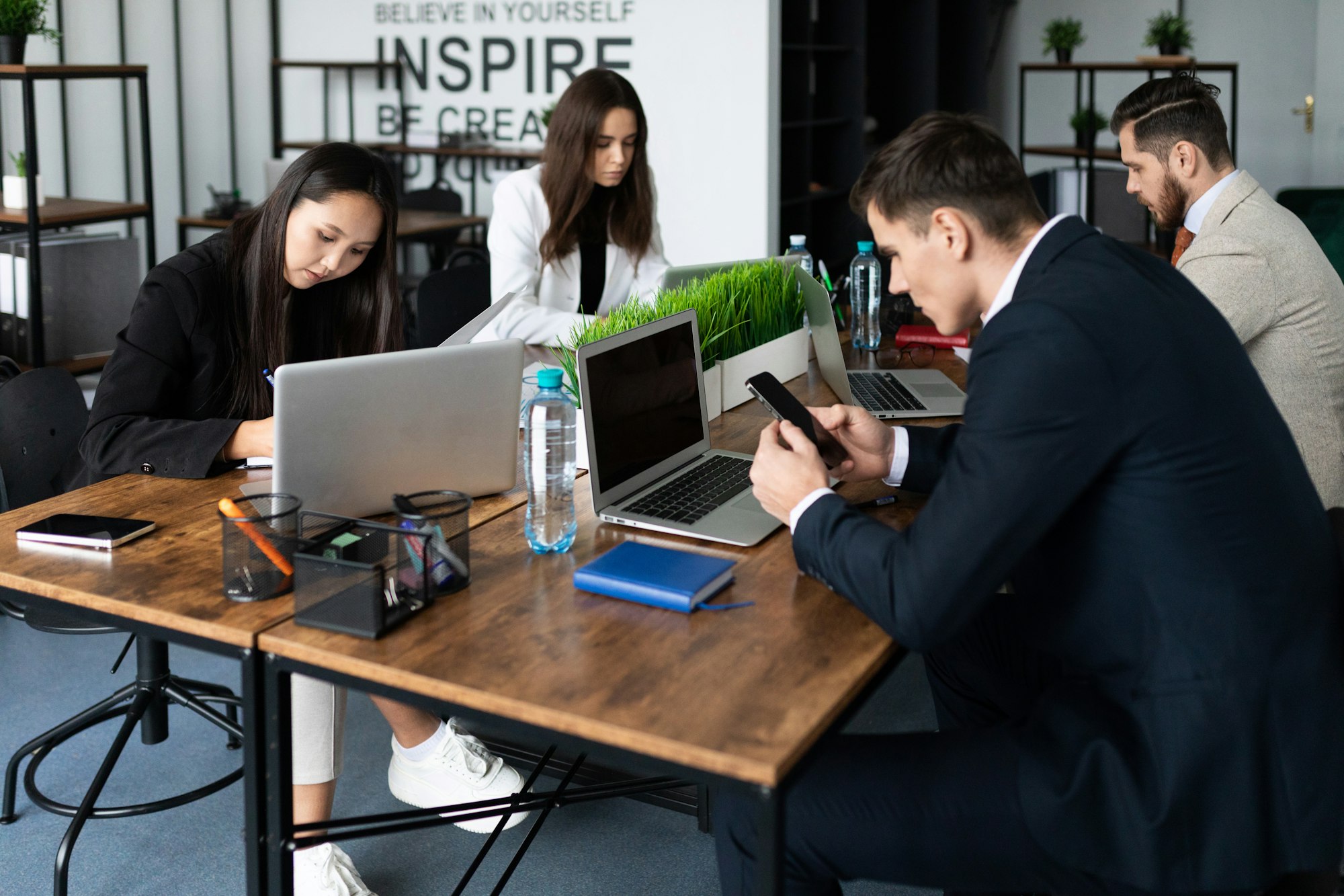 working days in the office employees sit in open space and work on laptops and phones in business